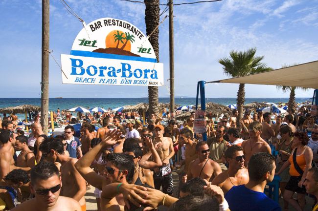 Teenagers enjoying at the Bora-Bora Beach bar in Ibiza, Spain.